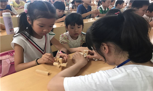 志愿者帮助小朋友组装.jpg 志愿者帮助小朋友组装.jpg